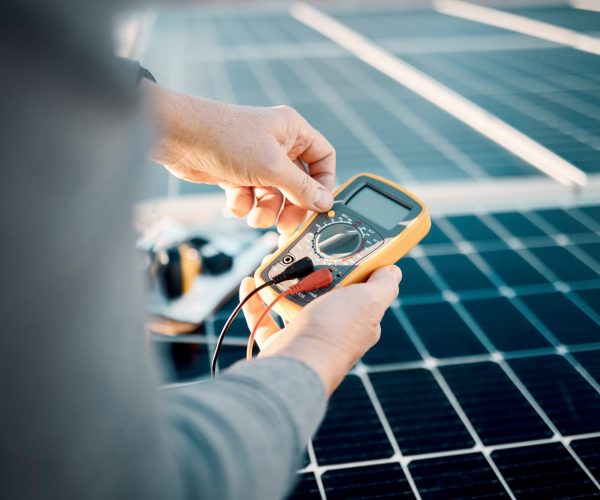 solar-panels-multimeter-and-engineering-hands-scaled